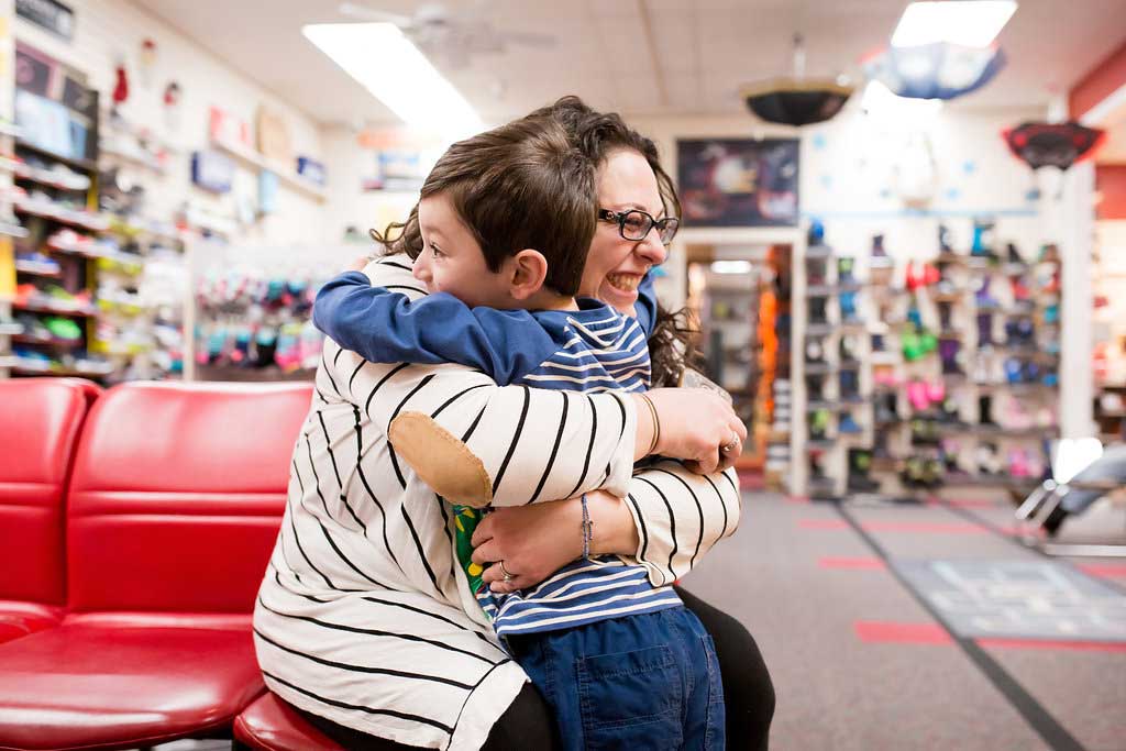 child hugging sales clerk