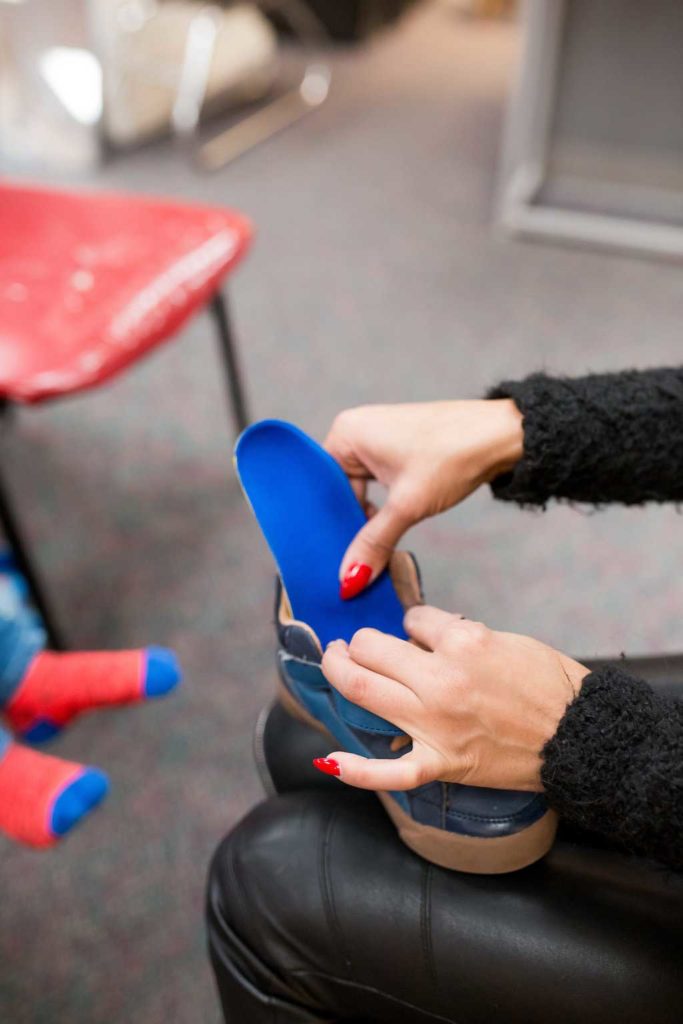 Orthotics being inserted into shoes